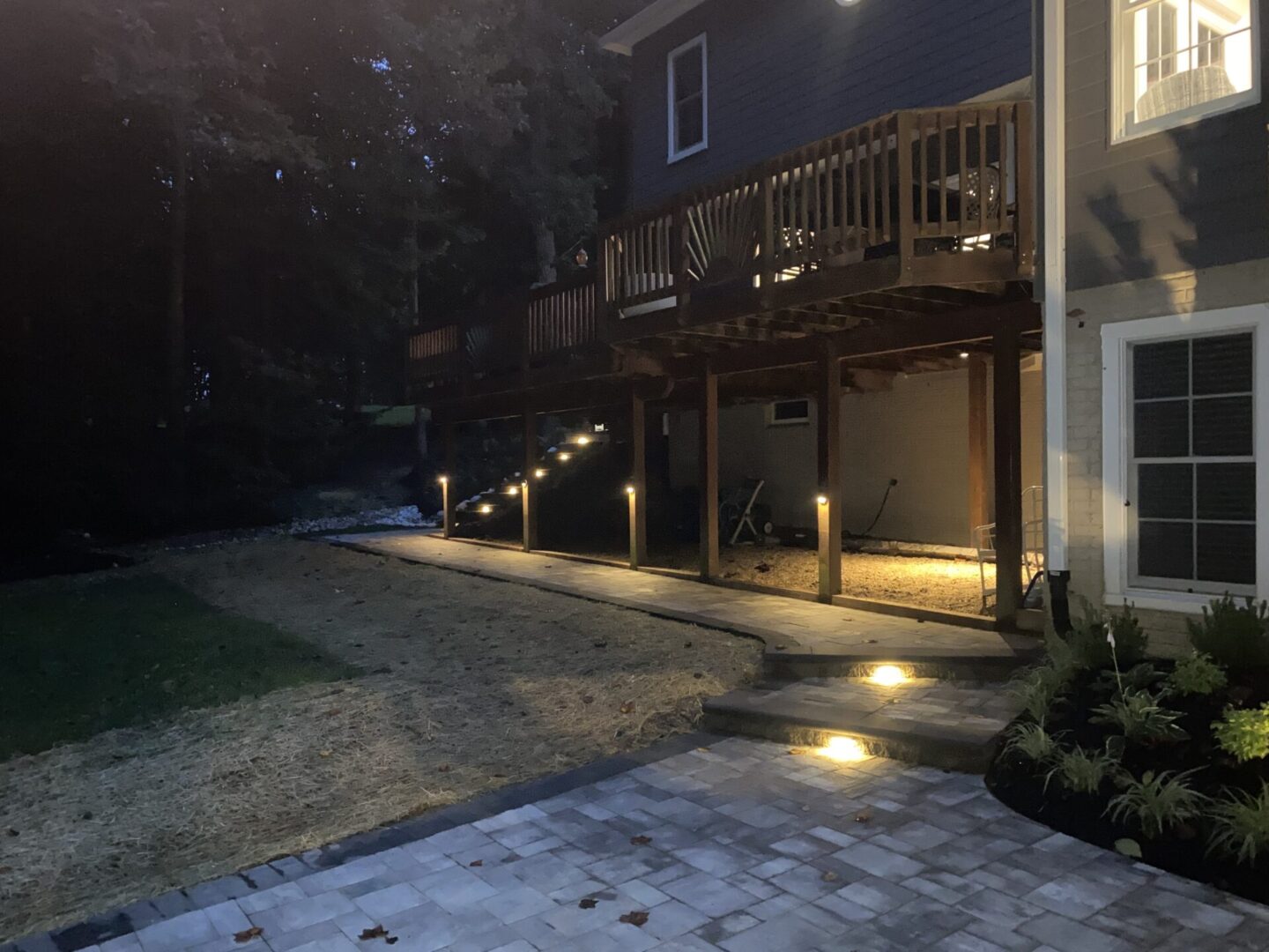 A patio with lights and a walkway at night.
